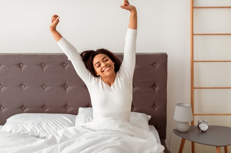 Peaceful morning stretch in bed after restful sleep.