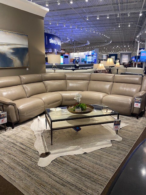 A cowhide rug, layered on top of another rug in The Furniture Mall.