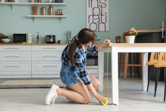 woman measuring small rustic dining table