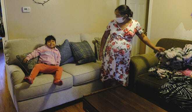 Arelis López Guzman watches her daughter Samantha Menchu López jump on the new sofa from Furniture Mall of Texas, donated as part of the Statesman's Season for Caring campaign.