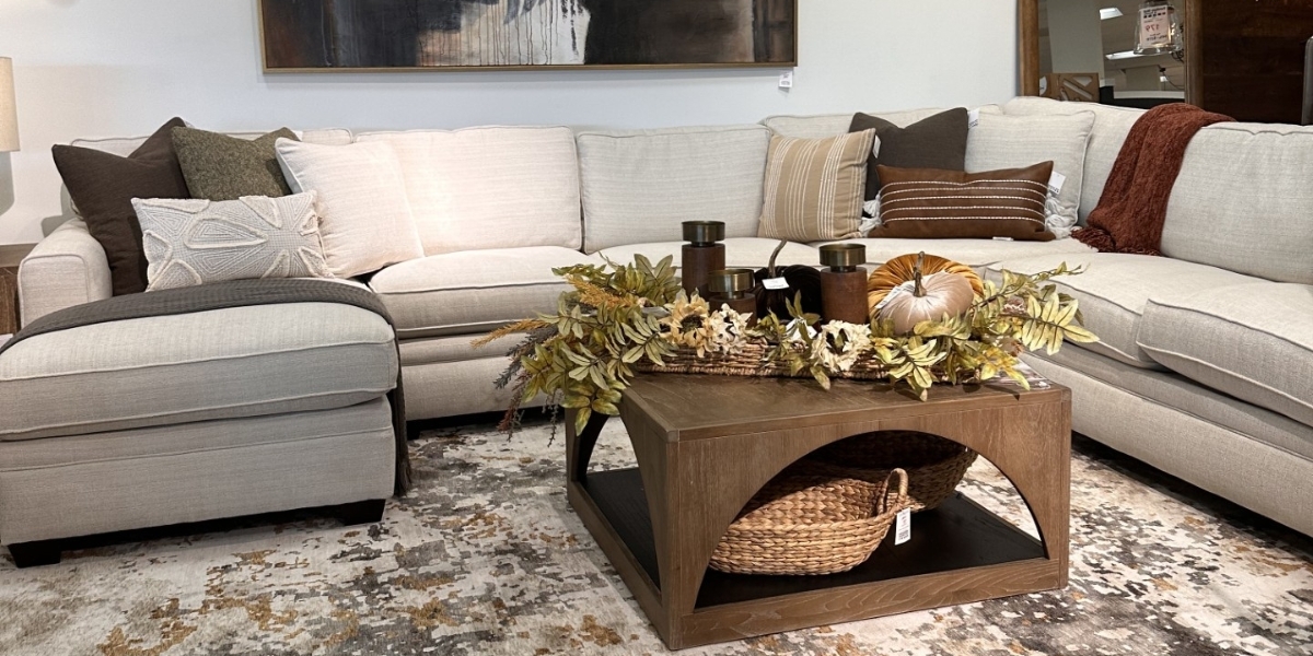 Fall living room display at Furniture Mall in Topeka featuring rust accents, neutral pumpkins, fall leaves and cozy textures.
